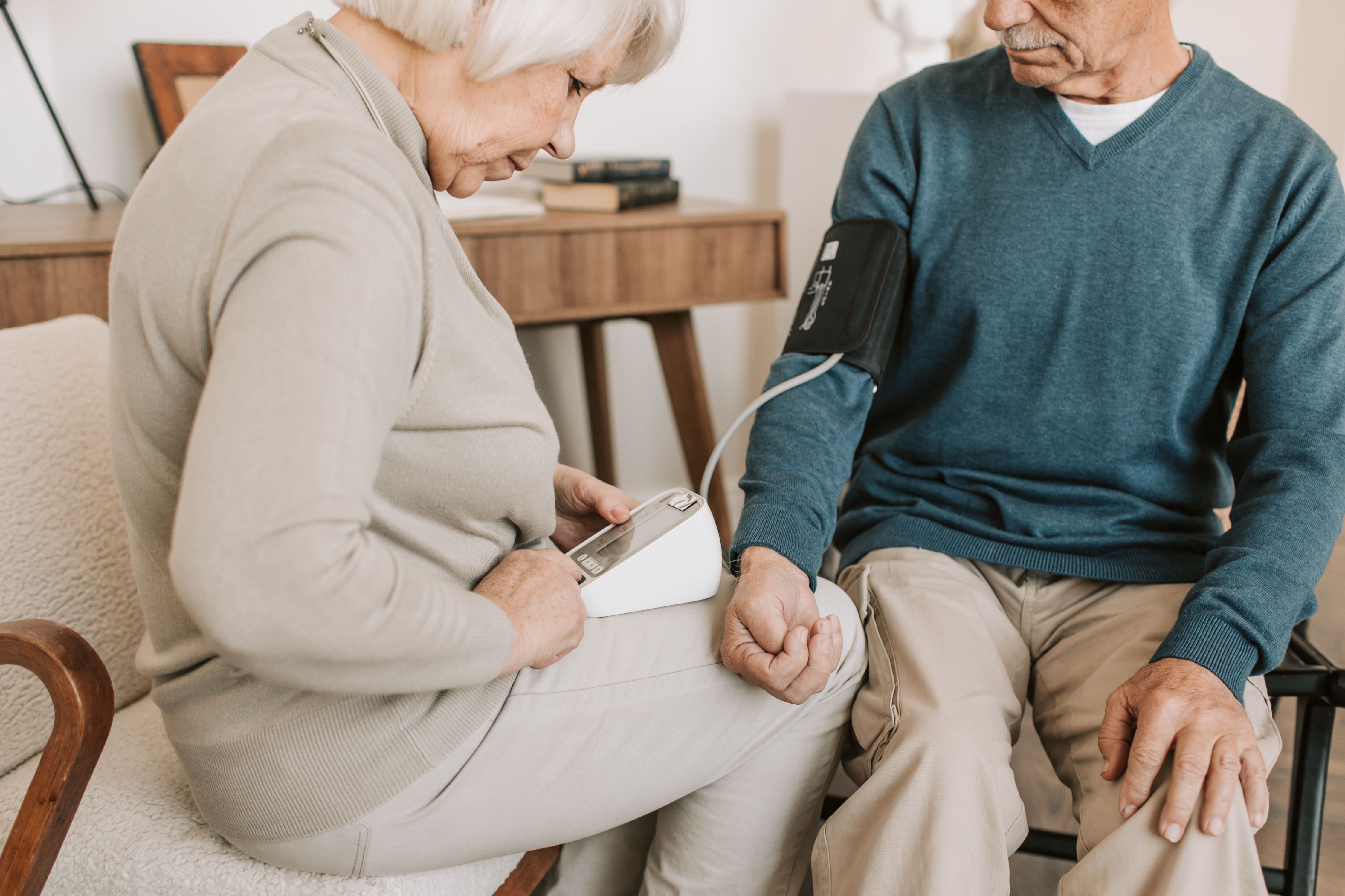 Pareja de adultos mayores revisando la presión arterial en casa, imagen ilustrativa sobre Medicare 2027