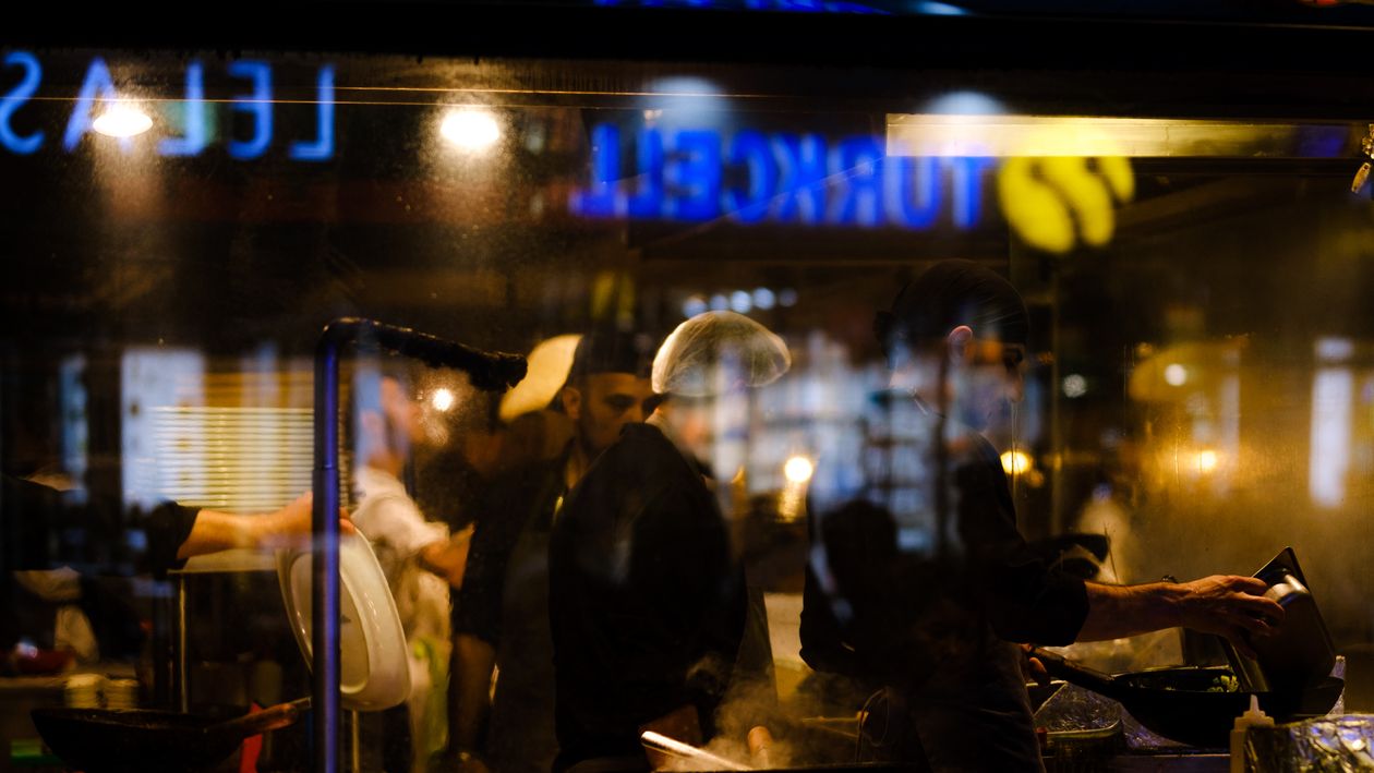 Trabajadores en una cocina de restaurante durante un turno nocturno.
